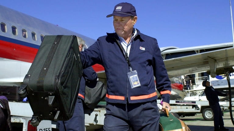 U.S. Sen. Bob Graham, D-Fla., unload bags from a USAir...