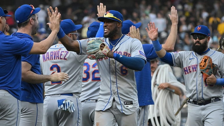 Starling Marte #6 of the Mets high-fives with teammates following a...