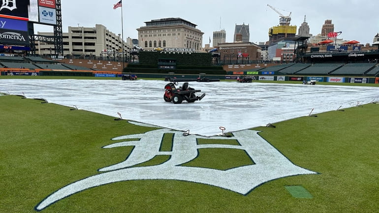 A tarp covers the Comerica Park field before a baseball...