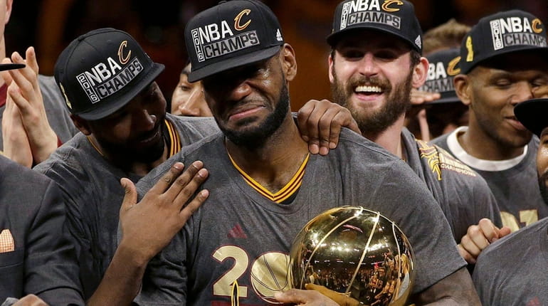Cleveland Cavaliers forward LeBron James, center, celebrates with teammates, including...
