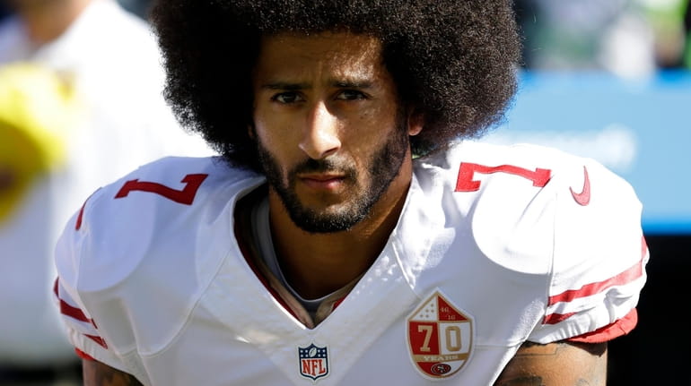 San Francisco 49ers quarterback Colin Kaepernick kneels during the national...
