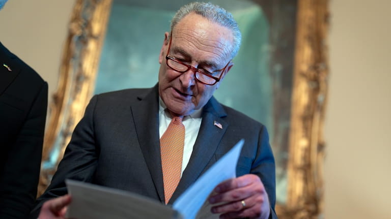 Senate Majority Leader Chuck Schumer, D-N.Y., looks over his notes...