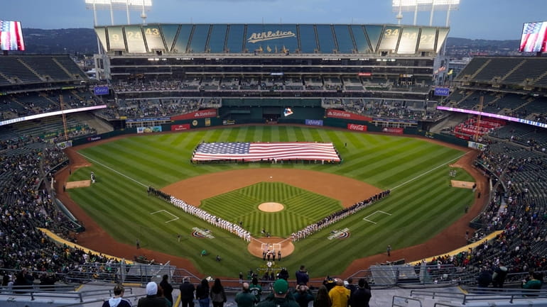 The Oakland Athletics and the Cleveland Guardians listen to the...