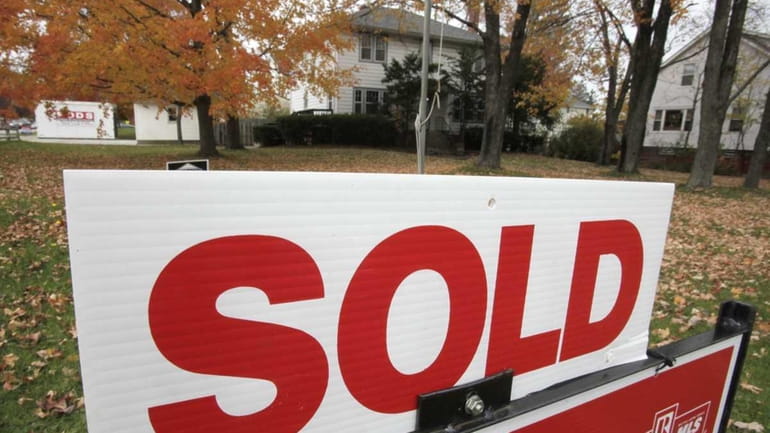 A sold sign stands outside a house in Mayfield Heights,...