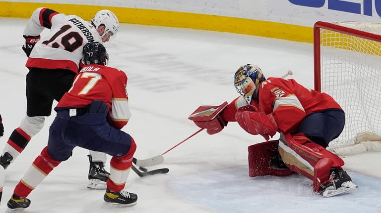 Florida Panthers defenseman Niko Mikkola (77) defends Ottawa Senators right...