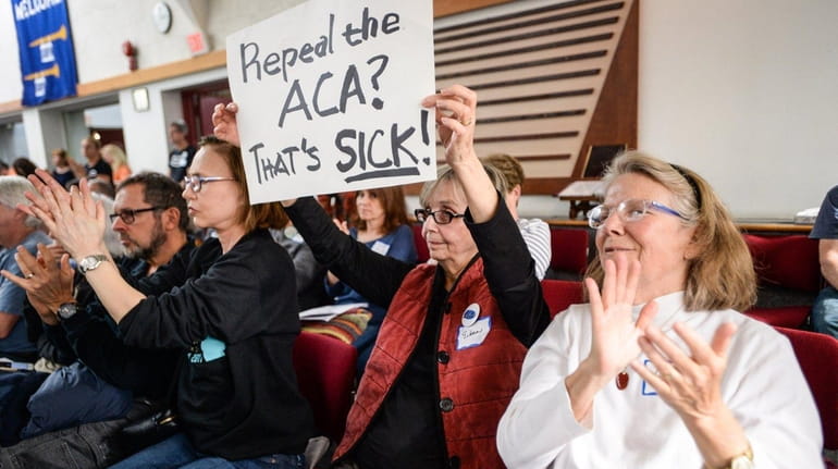 Eileen Bruning of Huntington holds up a sign opposing the...