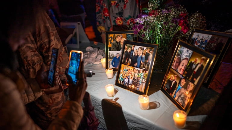 People view photos on display during a vigil for Riley...