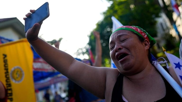 A protester celebrates upon learning that Panama's Supreme Court has...