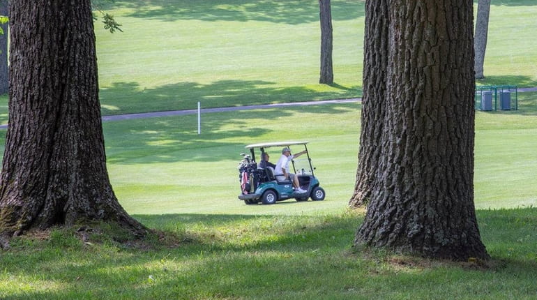 A cart is driven down the fairway at Smithtown Landing...