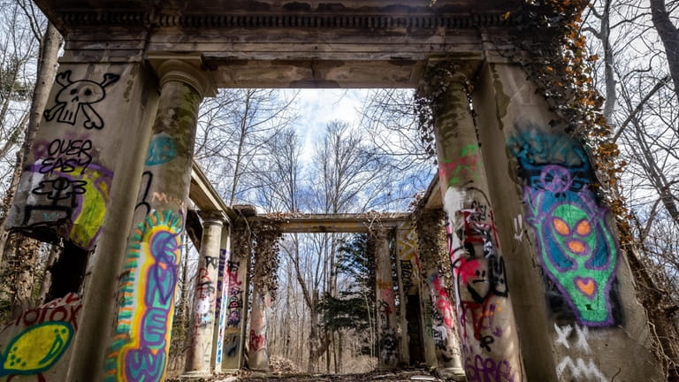 Grafitti adorns the ruins of the former estate of an...