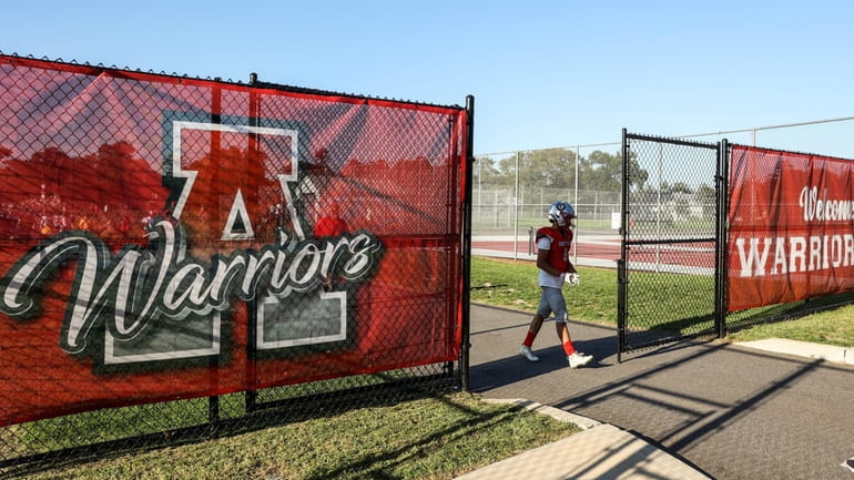 Players walk past the Amityville Warriors logo during the Suffolk...