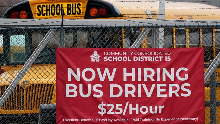 A hiring sign is displayed at a school in Palatine,...