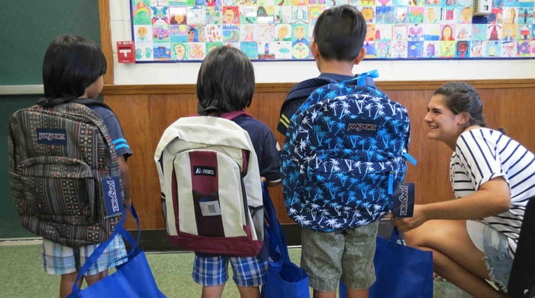 Westhampton Beach Elementary School students show off the new backpacks...
