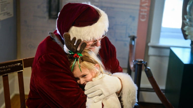 Sierra Stachurski, 4, of Amityville, hugs Santa during a re-enactment...