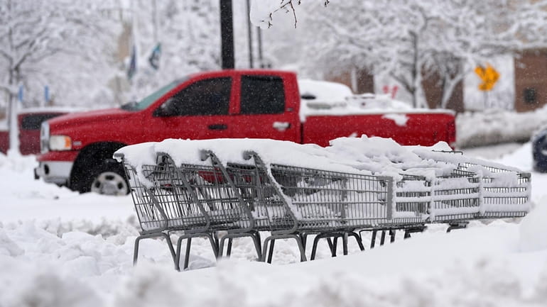 Shopping carts topped with heavy snow sit marooned in the...