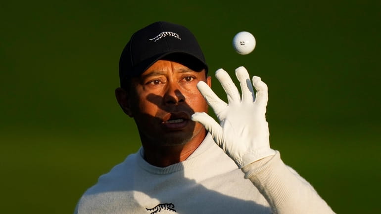 Tiger Woods catches a golf ball on the driving range...
