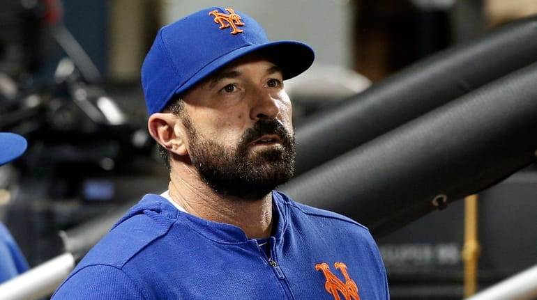 Manager Mickey Callaway of the Mets looks from the dugout...
