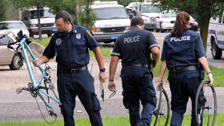 Police remove pieces of a bicycle near Patchogue Avenue in...
