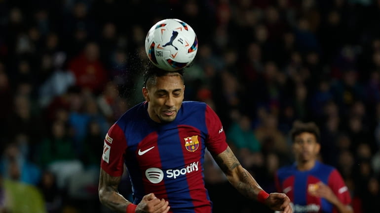 Barcelona's Raphinha heads the ball to scores his side's opening...