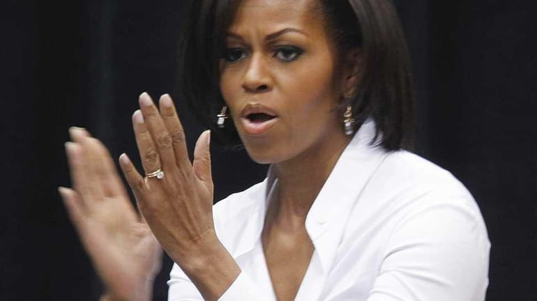 First lady Michelle Obama applauds as she arrives to speak...