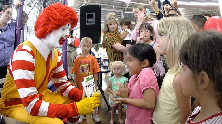Ronald McDonald visits with children at a McDonald's Restaurant in...