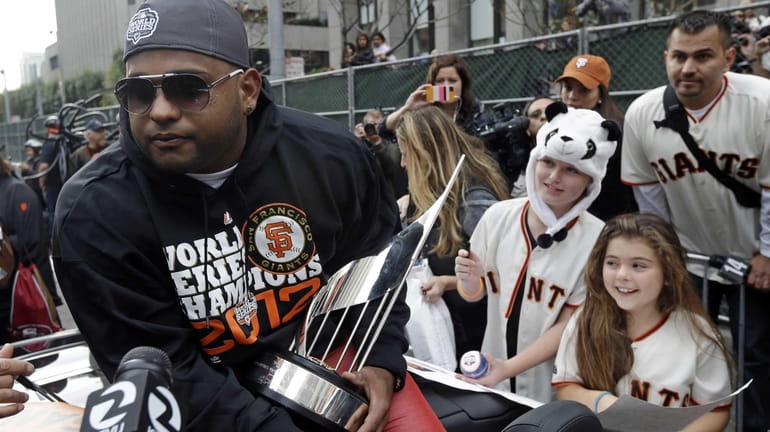 San Francisco Giants Pablo Sandoval holds the MVP trophy as...