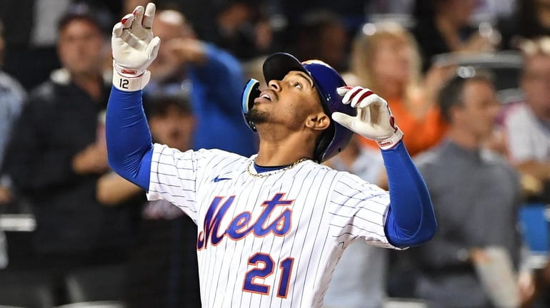 Mets shortstop Francisco Lindor reacts as he scores on his...