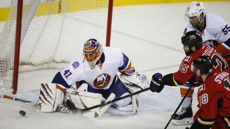 New York Islanders goalie Jaroslav Halak, left, blocks the net...