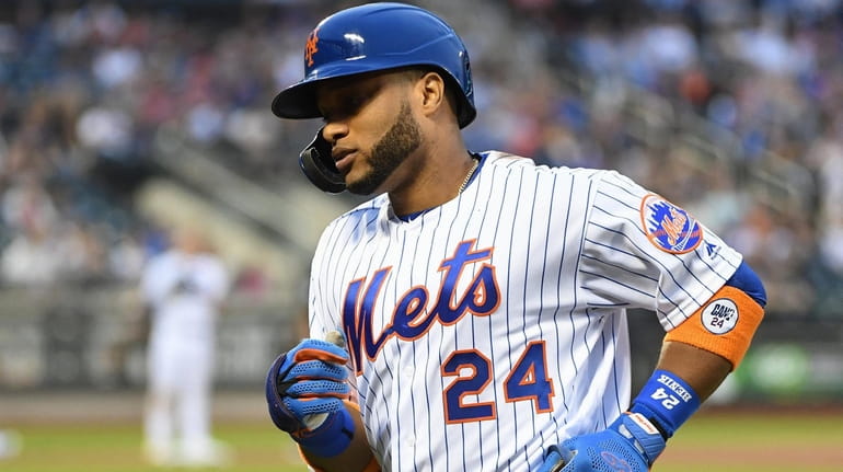 Mets second baseman Robinson Cano returns to the dugout after...