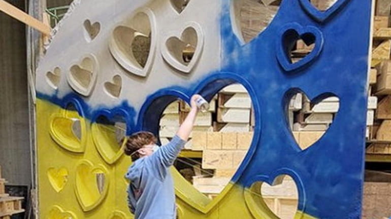 Ryan Hirschhorn, 13, works on his art piece, “Hearts for Ukraine,” a tribute...