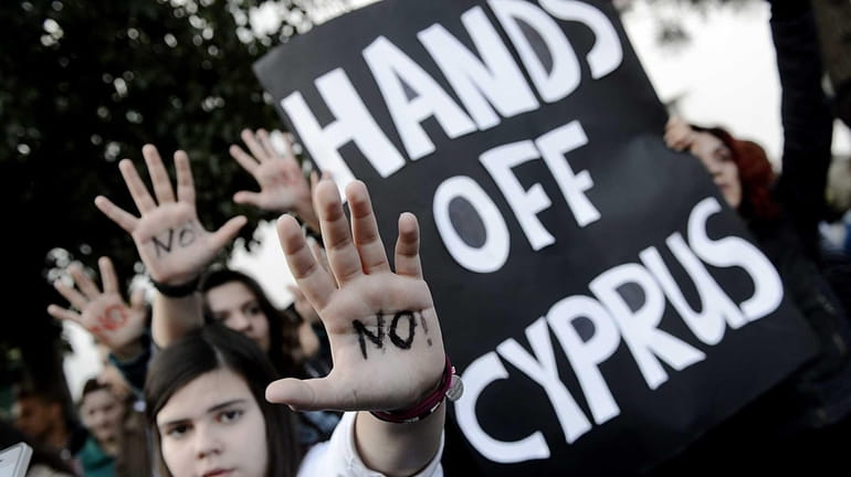 Protesters rally in Nicosia, Cyprus, against a one-time tax on...