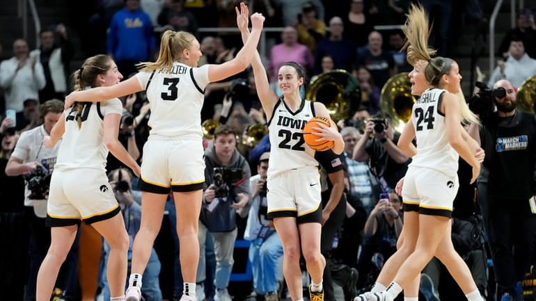 Iowa guard Caitlin Clark (22) celebrates with teammates after defeating...