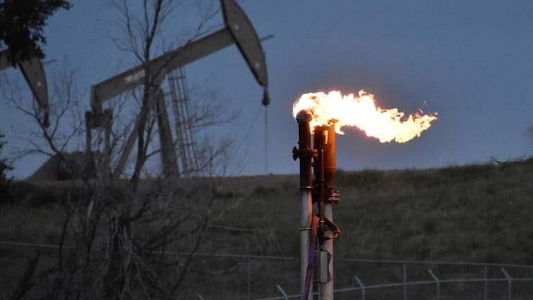 A flare burns at a well pad Aug. 26, 2021,...
