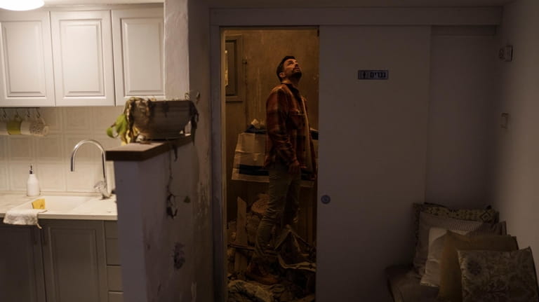 Nadav Tzabari looks at the damage inside his home in...