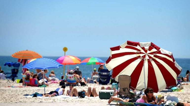 Umbrellas line the beach at Jones Beach. Check the current...
