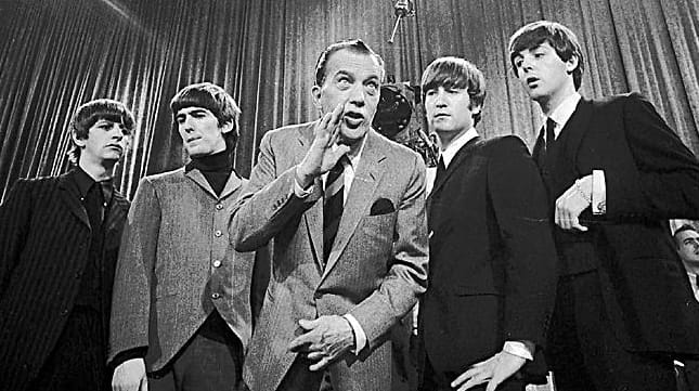 Show host Ed Sullivan, center, with members of The Beatles...