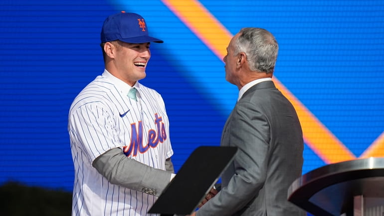 Kevin Parada, left, shakes hands with MLB Commissioner Rob Manfred...
