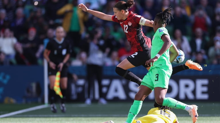Canada's Christine Sinclair leaps over Nigeria's goalkeeper Chiamaka Nnadozie after...