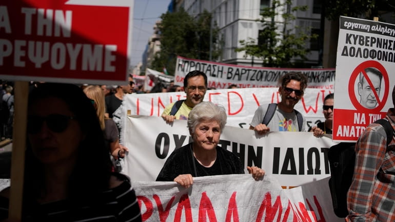 Protesters hold banners during a rally in Athens, Greece, Wednesday,...