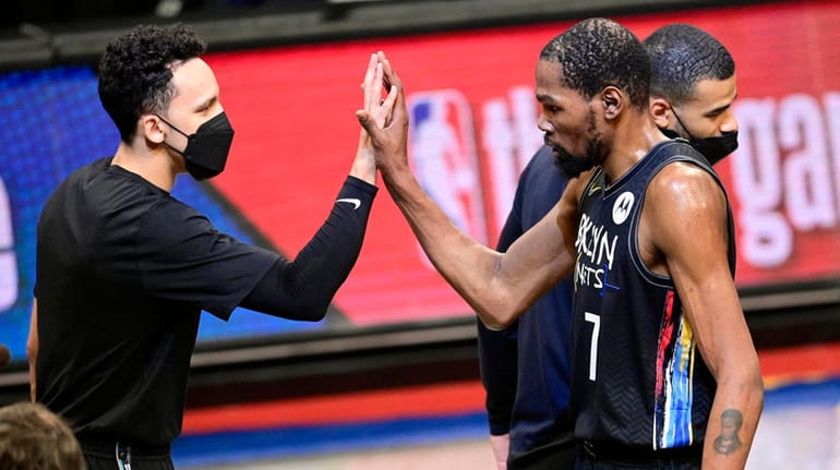 Kevin Durant of the Nets congratulated by Landry Shamet after scoring a...