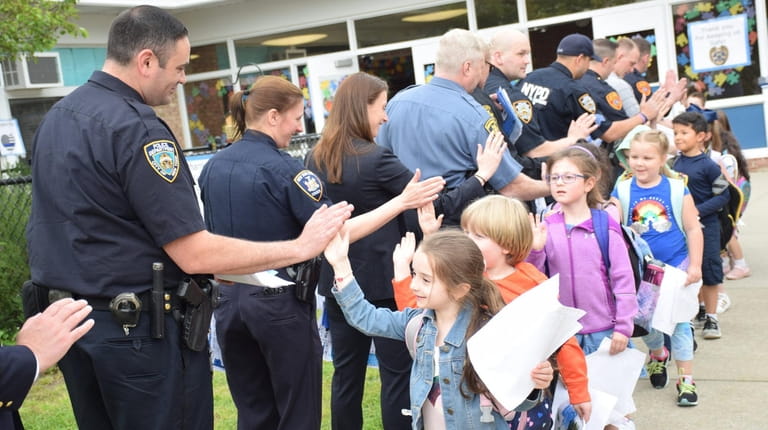 Students at Grundy Avenue Elementary School in Holbrook give high-fives...