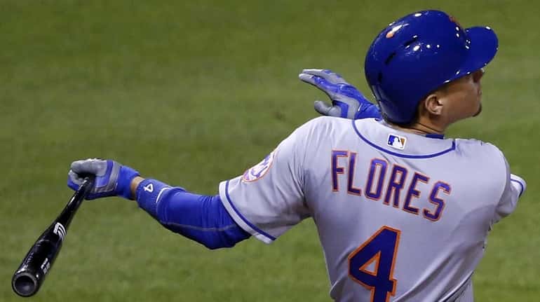 New York Mets' Wilmer Flores drives in a run with...