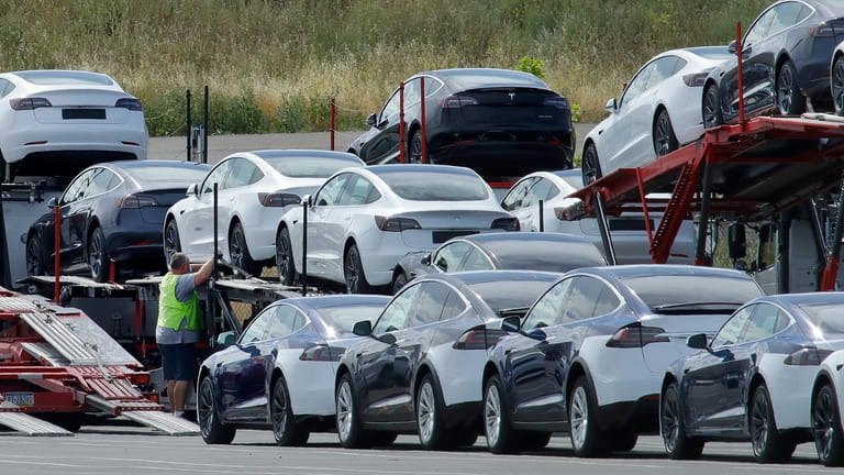 Tesla cars are loaded onto carriers at the Tesla electric...