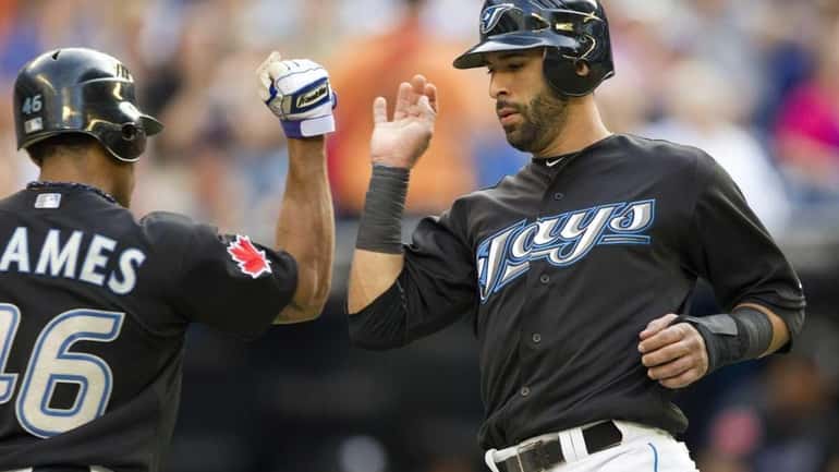 Blue Jays' Jose Bautista, right, is congratulated by Eric Thames...