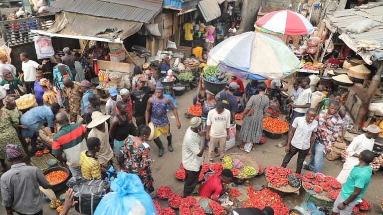 Pedestrians shop for pepper and other food items at the...