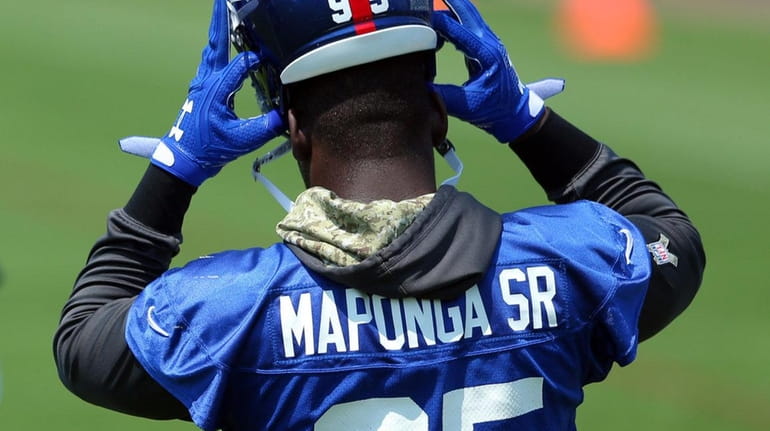 Giants defensive end Stansly Maponga Sr. puts on his helmet...