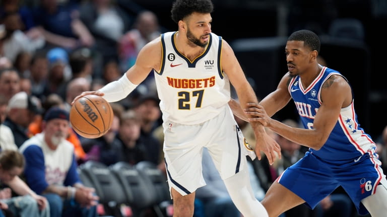 Denver Nuggets guard Jamal Murray, left, looks to pass the...