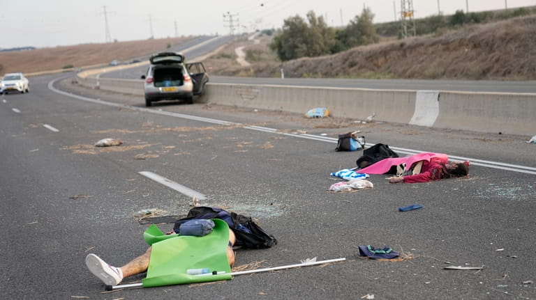 Israelis killed by Hamas militants lie on the road near...