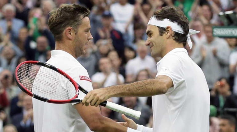 Roger Federer of Switzerland, right, shakes hands with Marcus Willis...