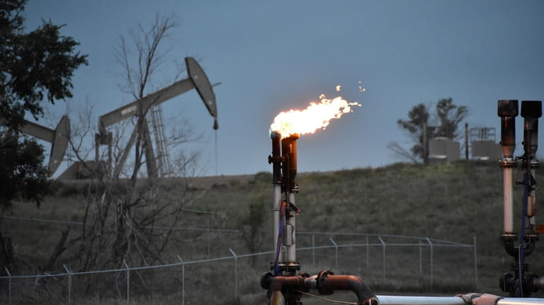 A flare to burn methane from oil production is seen...